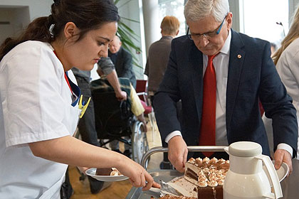 Herr Seifert, Pflegedienstleiter, 
                half mit die Torte zu verteilen.